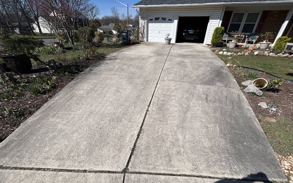 Grey, algae-stained concrete driveway before pressure washing in West Springfield VA