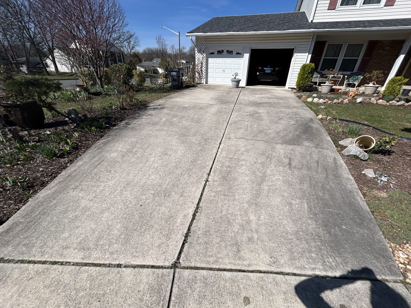 Grey, algae-stained concrete driveway before pressure washing in West Springfield VA